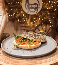 BAGEL DE QUESO CREMA, SALMÓN AHUMADO Y RÚCULA DE LA HUERTA