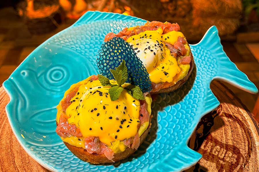 SALMÓN BENEDICT: Dúo de huevos poché con salmón, guacamole y salsa holandesa.